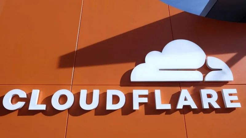 The Cloudflare logo and wordmark mounted on an orange building exterior